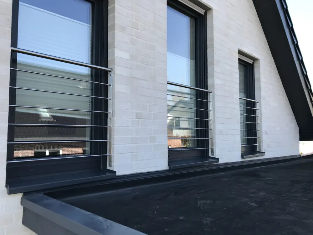 Fenstergeländer aus Edelstahl an einem Klinkerneubau