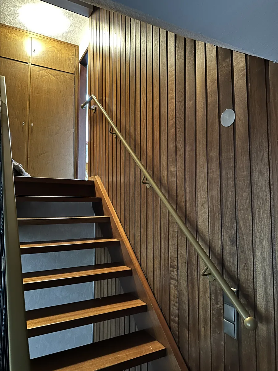 Handlauf aus Messing im Treppenhaus mit Holzvertäfelung