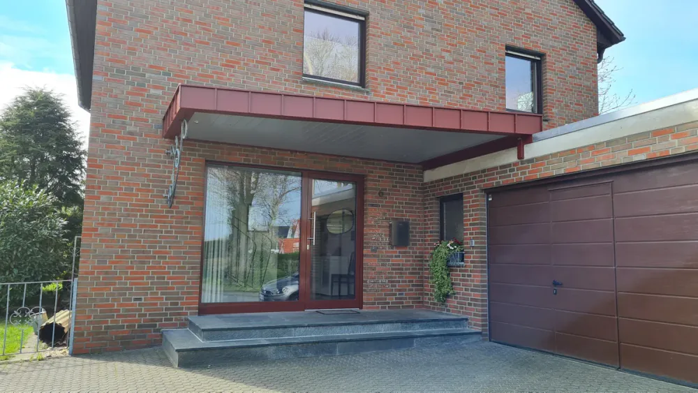 Aluminium-Vordach in Rotbraun über Hauseingang und Garage