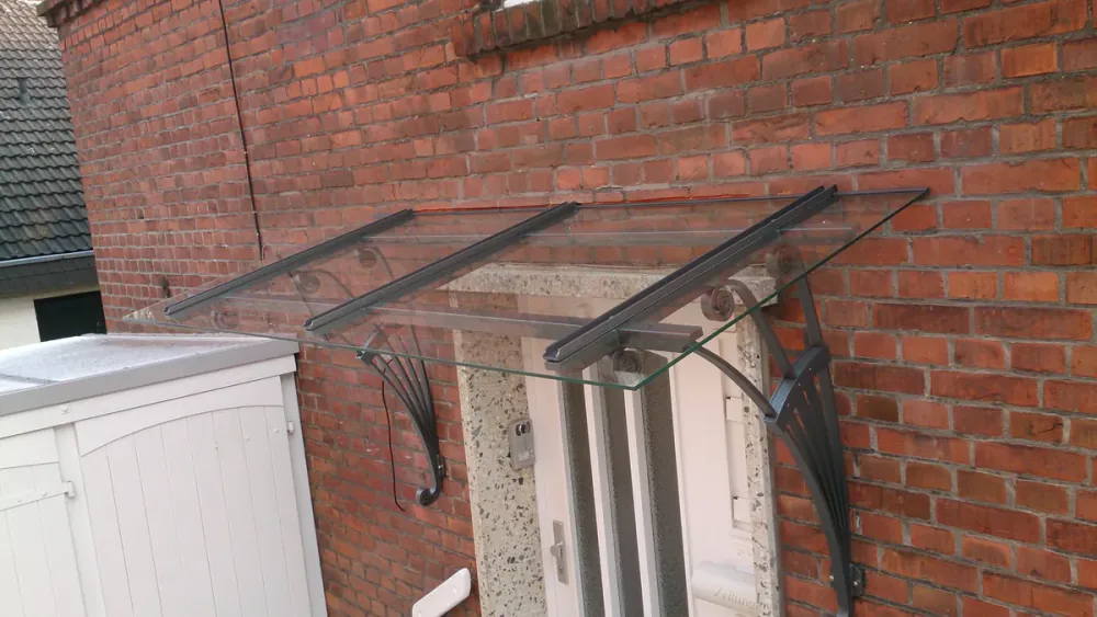 Glasvordach im Jugendstil mit geschwungenen Konsolen